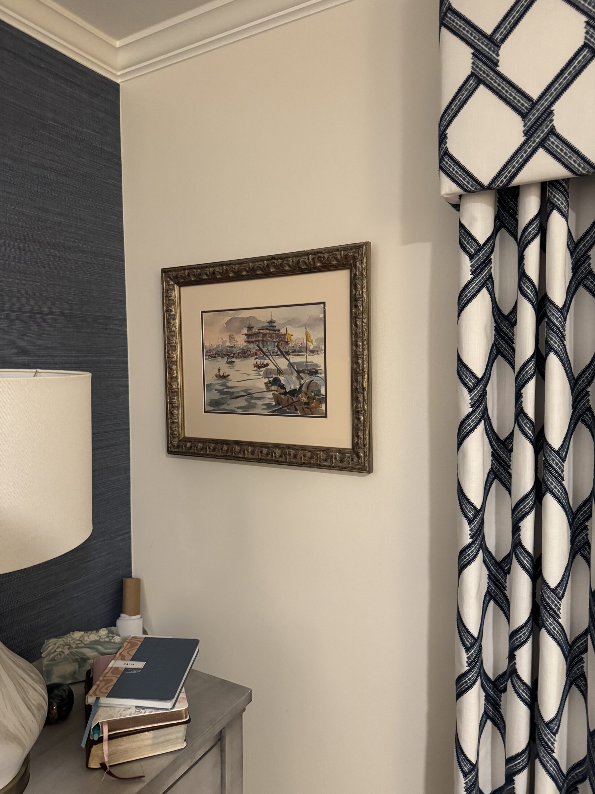 Framed watercolor harbor painting hung centered above a nightstand in a Ponte Vedra bedroom