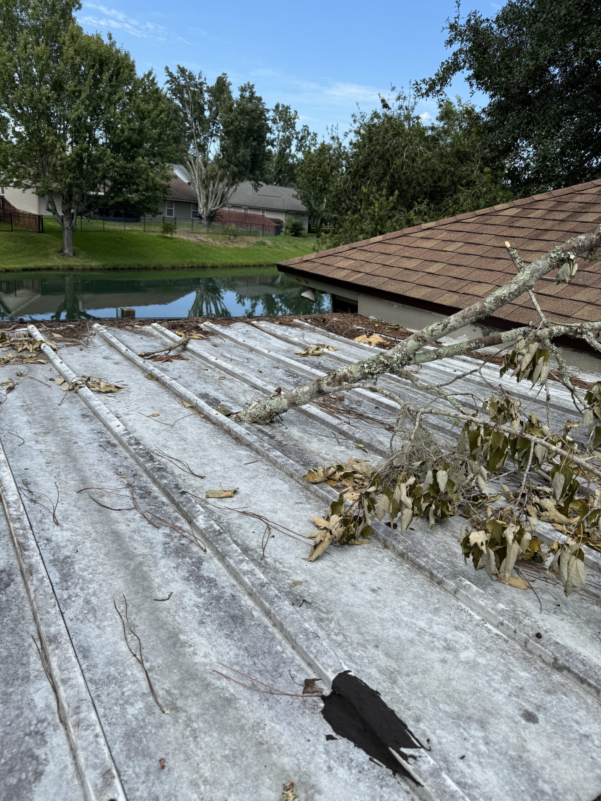 Storm-damaged patio roof with a hole before a Jacksonville patio roof patch, view 1