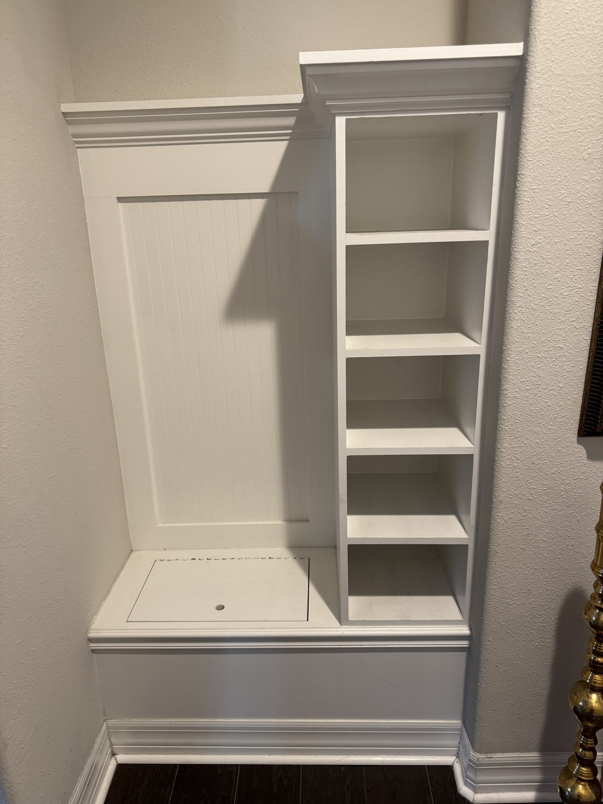 Built-in cabinet before removal, hiding a gap in the hardwood floor underneath in a Nocatee home