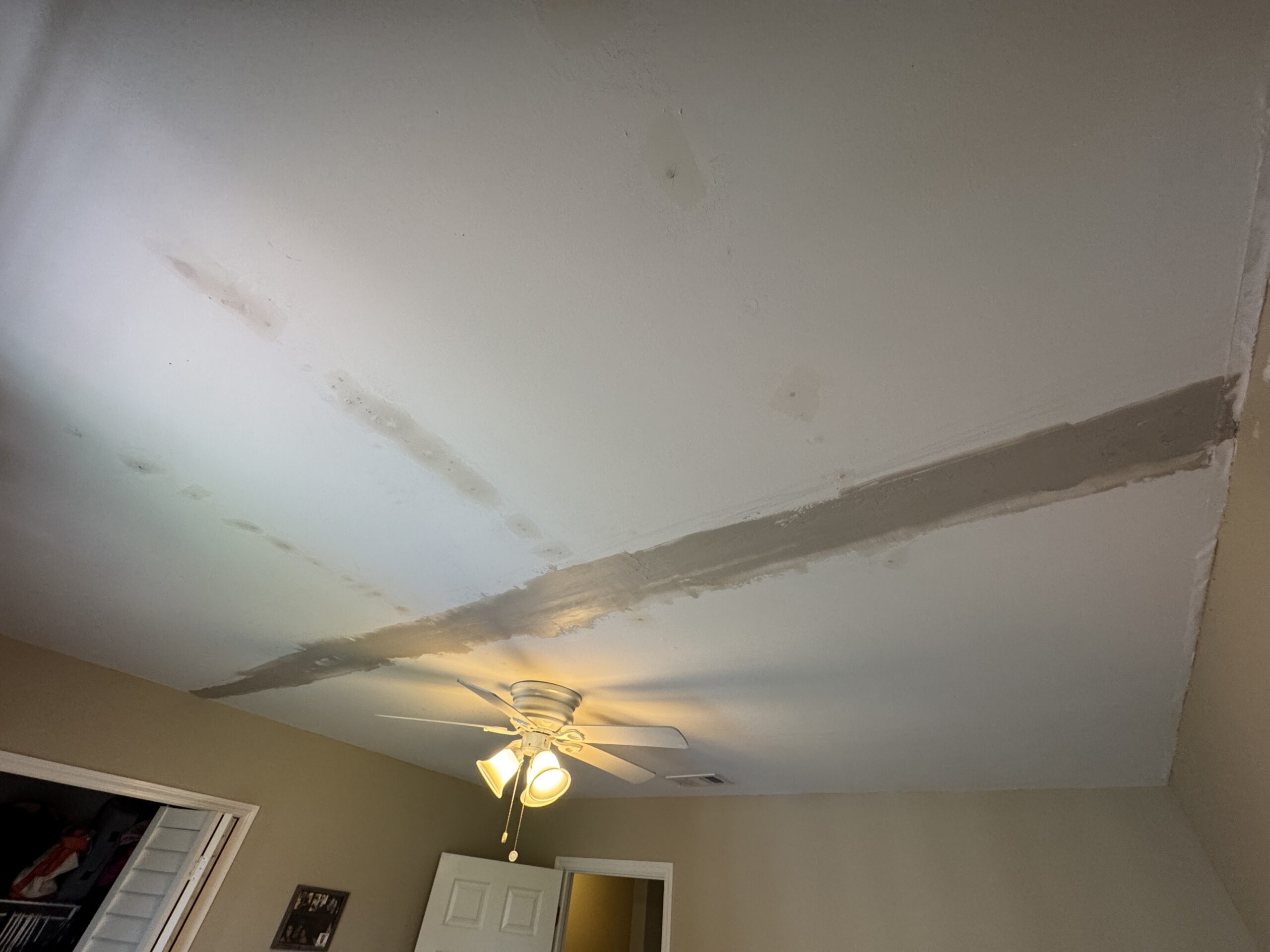 Ponte Vedra Ceiling Tape Repair — And the Sagging Drywall We Found Underneath 5 Sagging drywall being screwed back into the joists during a Ponte Vedra ceiling tape repair, step 4